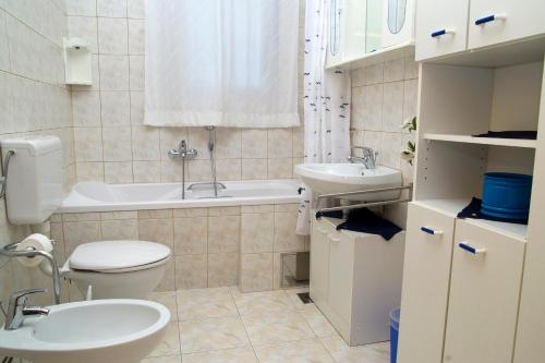 a bathroom with a toilet and a sink and a tub at Sunshine Apartments Podstrana in Podstrana