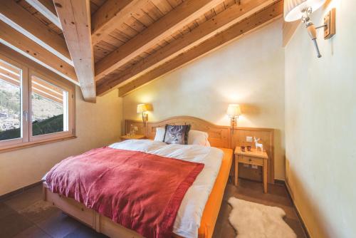 1 dormitorio con 1 cama grande en una habitación con ventana en Apartment Alpharmonie en Zermatt