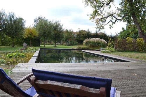 a bench sitting on a deck next to a pond at Vijverhoef in Ulicoten