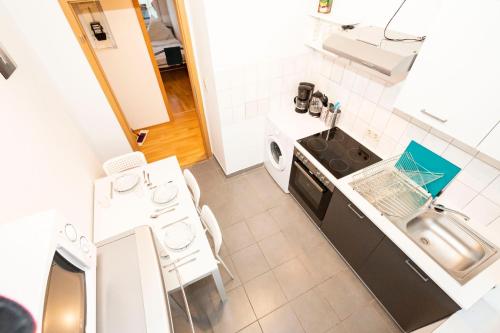 uma pequena cozinha com um lavatório e um fogão em AVR Apartment HOF 11 em Bremerhaven