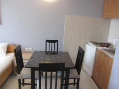 a table and chairs in a small kitchen with a refrigerator at Cernogoriya voyage in Rafailovici