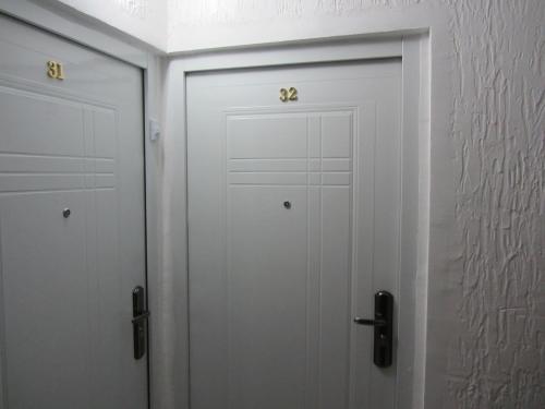 two white doors with gold handles in a room at Cernogoriya voyage in Rafailovici