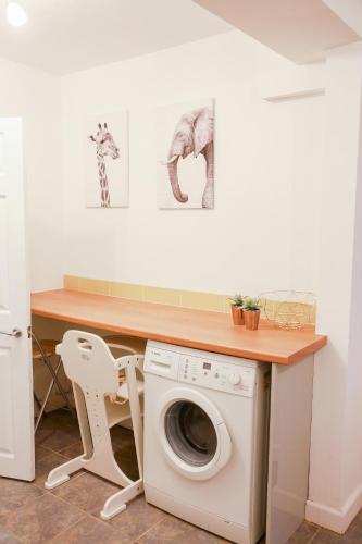 a laundry room with a washing machine under a counter at Zoo House Chester in Chester