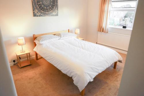 una camera da letto con un grande letto bianco e una finestra di Zoo House Chester a Chester