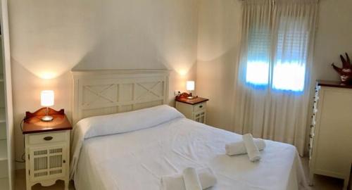 - une chambre avec un lit blanc et une fenêtre dans l'établissement Apartamento C.M., à Nerja