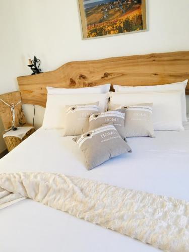 a bed with white sheets and pillows on it at Rossella alla Villarella dei Tulipani in Asti