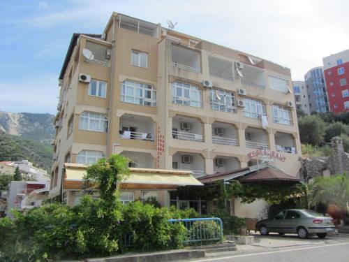a building with a car parked in front of it at Cernogoriya voyage in Rafailovici