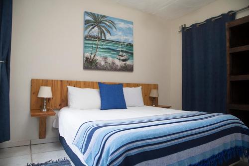 a bedroom with a bed with a blue and white blanket at Ansteys Beach Self Catering Apartments in Durban