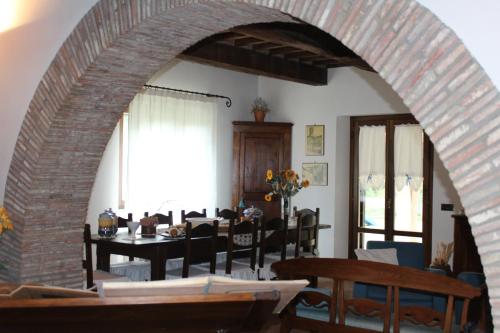 uma arcada numa sala de jantar com uma mesa em agriturismo trefossata em Abbadia San Salvatore