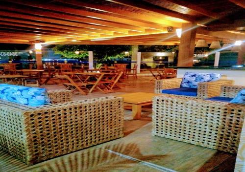 a restaurant with wicker chairs and tables in a room at Pousada Ilha Vitoria in Ubatuba
