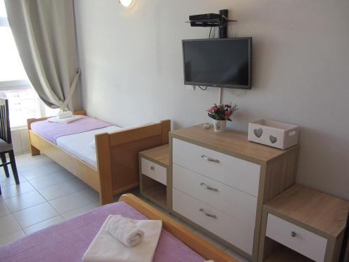 a small bedroom with a bed and a tv on the wall at Cernogoriya voyage in Rafailovici