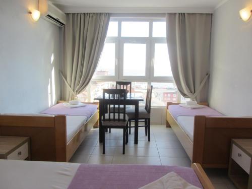a bedroom with two beds and a chair and a window at Cernogoriya voyage in Rafailovici