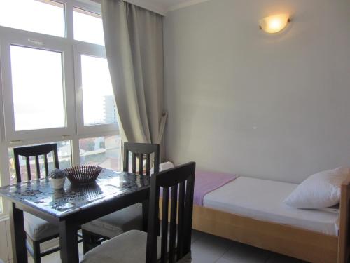 a bedroom with a table and a bed and a window at Cernogoriya voyage in Rafailovici