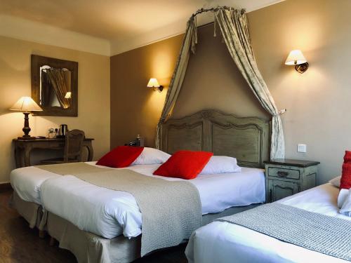 two beds in a hotel room with red pillows at Best Western Hôtel De La Bourse in Mulhouse