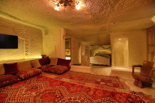 sala de estar con sofá y cama en Iris Cave Cappadocia en Ortahisar
