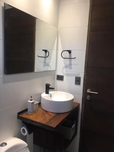 a bathroom with a white sink and a toilet at PUPUYA LODGE cabaña A, Matanzas in Matanzas