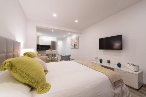 a bedroom with a large bed with yellow pillows at Sony Cosi Loft Canteras in Las Palmas de Gran Canaria