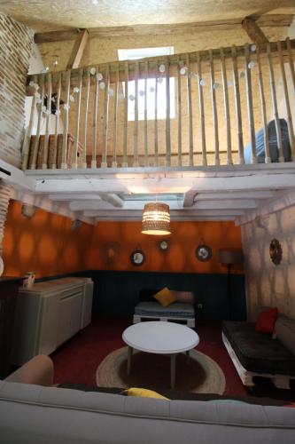 - un salon avec un canapé, une table et des escaliers dans l'établissement gite au coeur des chateaux de la loire, à Cour-sur-Loire