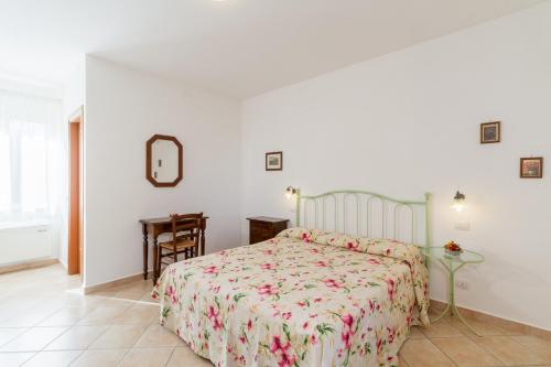 a bedroom with a bed and a table and a mirror at Agriturismo Valle Martina in Saturnia