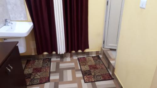 a bathroom with a sink and a shower with mats on the floor at Deluxe Residency in Kalpetta