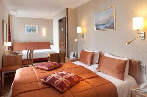 a hotel room with a large bed with two pillows on it at Hôtel la Croix Blanche in Le Mont Saint Michel