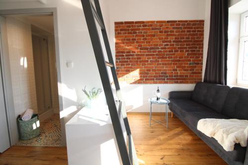 a living room with a couch and a brick wall at Aparthotel Tectum TectumApartments in Wrocław