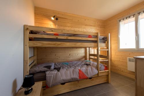 4 rue de la roque في Teissières-lès-Bouliès: غرفة نوم مع أسرة بطابقين في غرفة خشبية