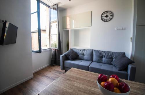 a living room with a couch and a bowl of fruit on a table at La Villa Tria Castella in Saint-Paul-Trois-Châteaux
