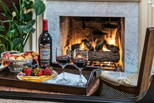 a table with two glasses of wine and a plate of food at Silver Heart Inn & Cottages in Independence