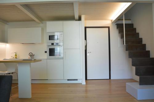 una cocina con armarios blancos y una escalera en bright and silent apartment near two towers en Bolonia