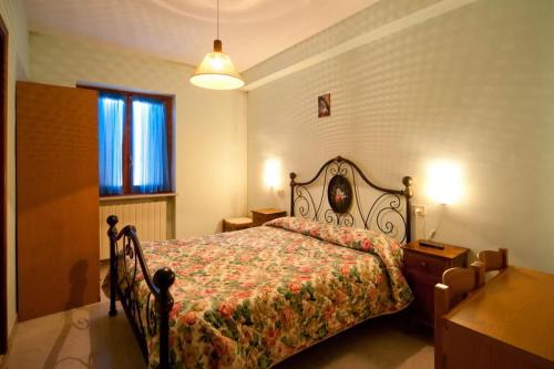 a bedroom with a bed with a floral bedspread at Hotel Cascia Ristorante in Cascia