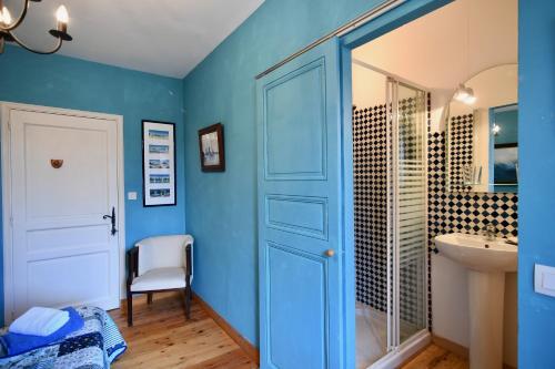 baño con puerta azul y lavamanos en La TULIPE SAUVAGE, en Bourdeaux