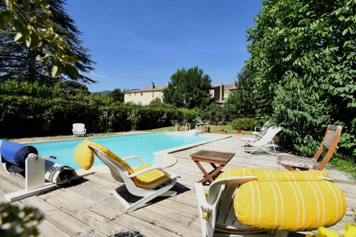 une piscine avec des chaises longues et une piscine dans l'établissement La TULIPE SAUVAGE, à Bourdeaux
