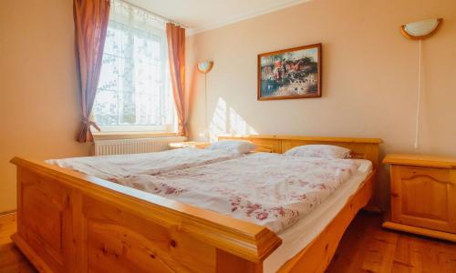 a bedroom with a wooden bed with a window at Penzión Exclusive in Trenčín