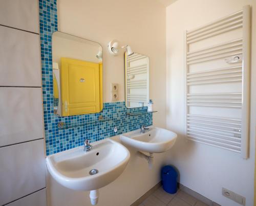 Un baño con dos lavabos y un espejo. en Le Gîte de la Faïencerie, en Passavant-en-Argonne