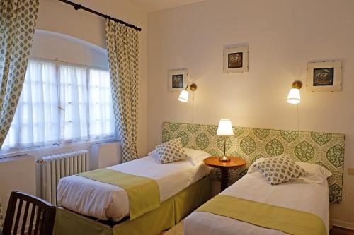 a hotel room with two beds and a window at Casa Rosa in Florence