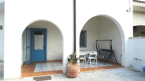 a house with a blue door and a table and chairs at Villa Lucky in Punta Prosciutto