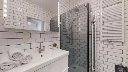 a white bathroom with a sink and a mirror at Na Szancach 8E TectumApartments in Wrocław