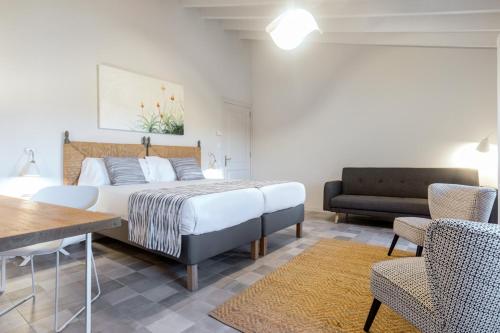 a bedroom with a bed and a table and chairs at Son Gris in Selva
