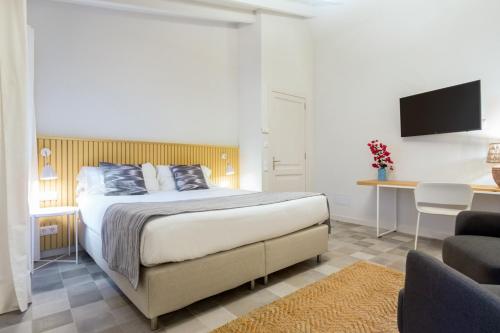 a bedroom with a bed and a desk and a television at Son Gris in Selva