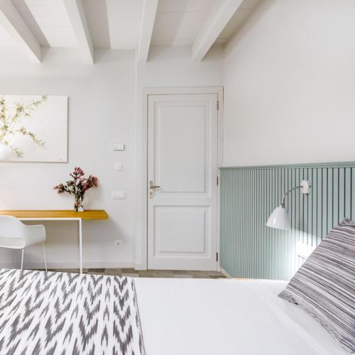 a bedroom with a bed and a desk and a door at Son Gris in Selva