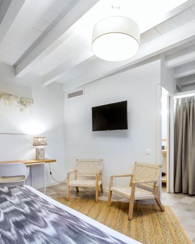 a bedroom with a bed and two chairs at Son Gris in Selva