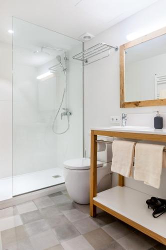 a bathroom with a toilet and a sink and a mirror at Son Gris in Selva