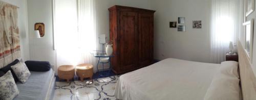 a bedroom with a white bed and a wooden cabinet at Villa Lucky in Punta Prosciutto