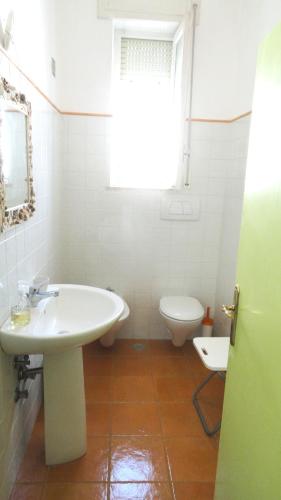 a white bathroom with a sink and a toilet at Villa Lucky in Punta Prosciutto