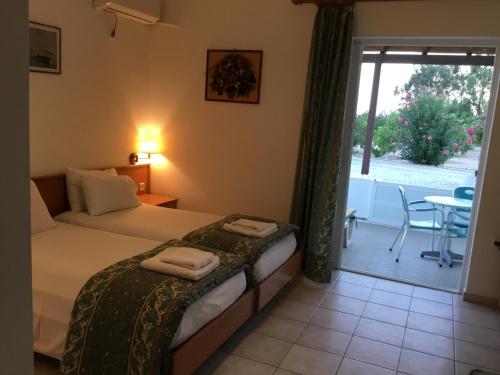 a bedroom with a bed with towels on it at VILLA EIRINI in Pefki