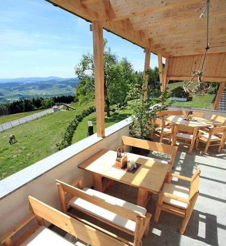 a patio with wooden tables and chairs on a roof at Landhotel Haagerhof in Aigen im Mühlkreis