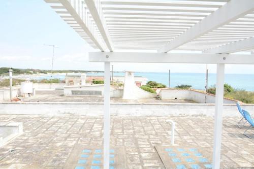 a white patio with a view of the ocean at Villa Lucky in Punta Prosciutto