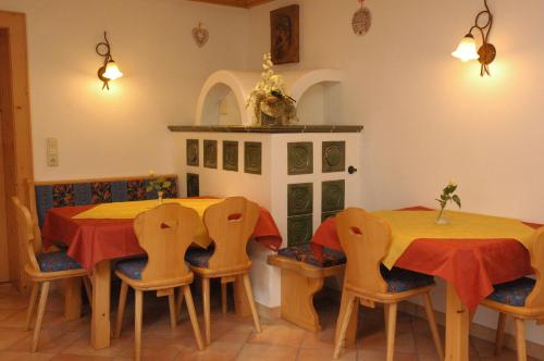 a dining room with two tables and four chairs at Pension Wolfsegg in Kirchberg in Tirol