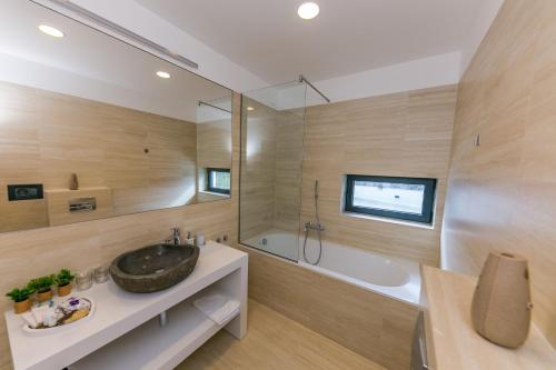 a bathroom with a sink and a shower and a tub at Villa Korina in Primošten